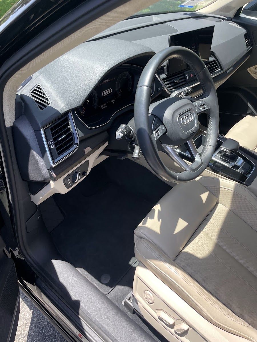 A clean Audi interior with the dashboard, screen and steering wheel wiped down