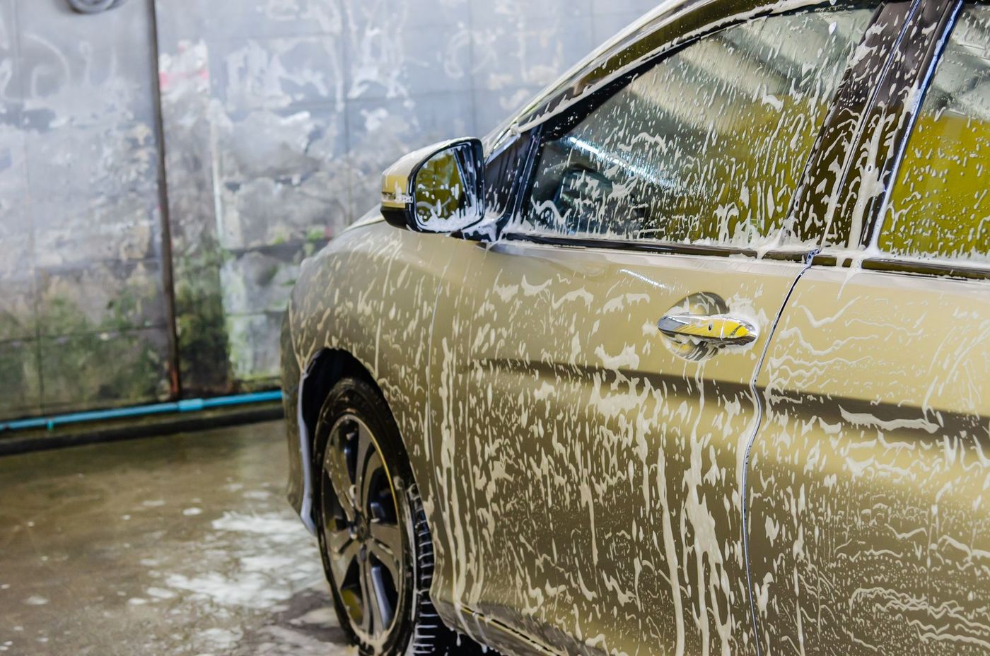 A car covered in wash foam during a hand wash