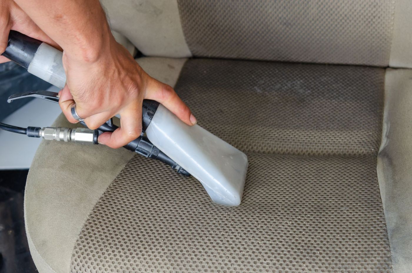 A car seat being cleaned with a steam and extraction tool